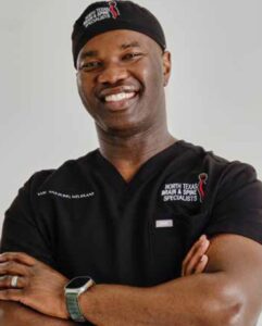 Smiling doctor in medical scrubs with crossed arms.